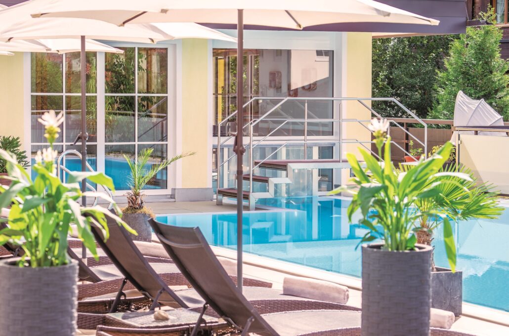 entspannen am aussenpool bei sonnenschein parkhotel burgmuehle