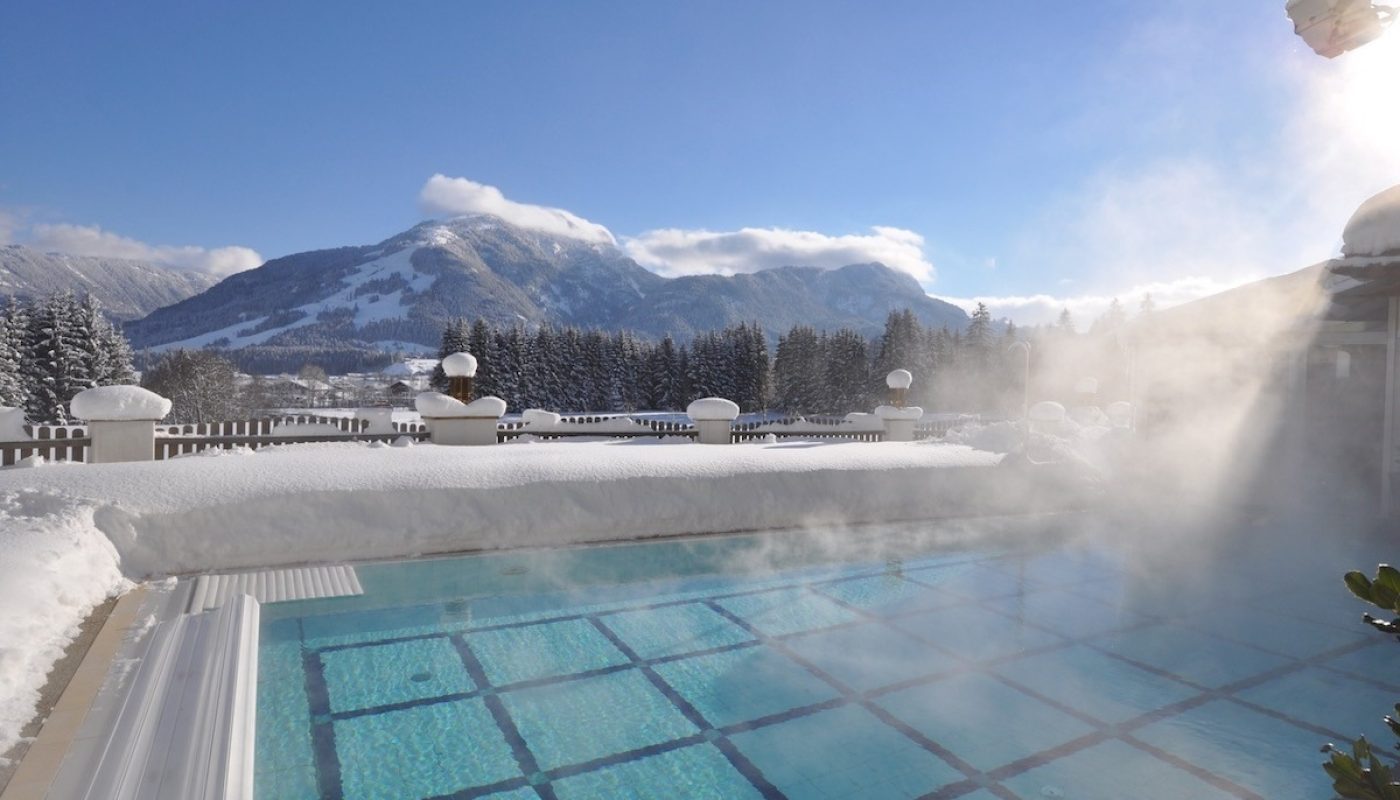 winterlicher_pool_mit_traumhaftem_bergblick_alpina_koessen